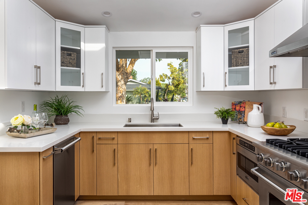 2048 Commodore Road Newport Beach, CA 92660 - Photo 14 of 39 a kitchen with stainless steel appliances granite countertop a sink a stove a window and cabinets