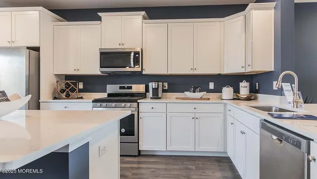 a kitchen with white cabinets and white appliances