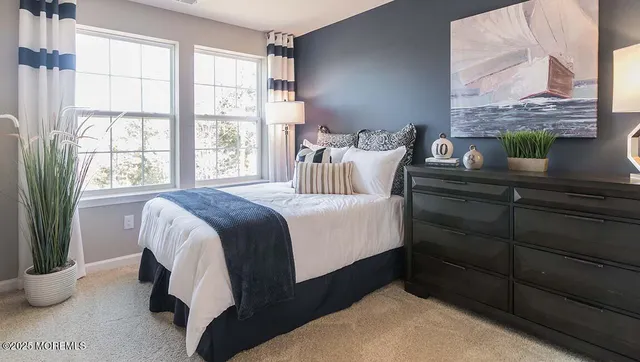 a bedroom with a bed and a potted plant on the dresser