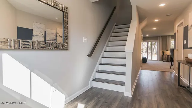 a view of a hallway with wooden floor and stairs