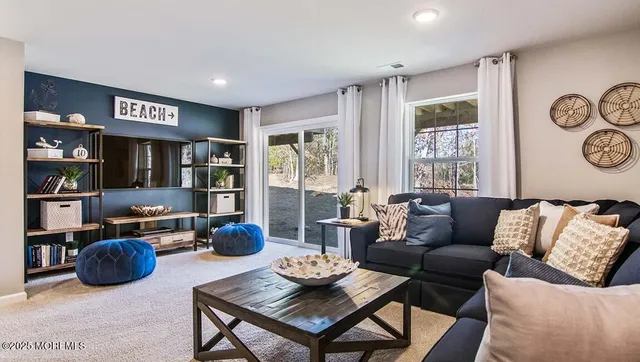 a living room with furniture a rug and wall painting