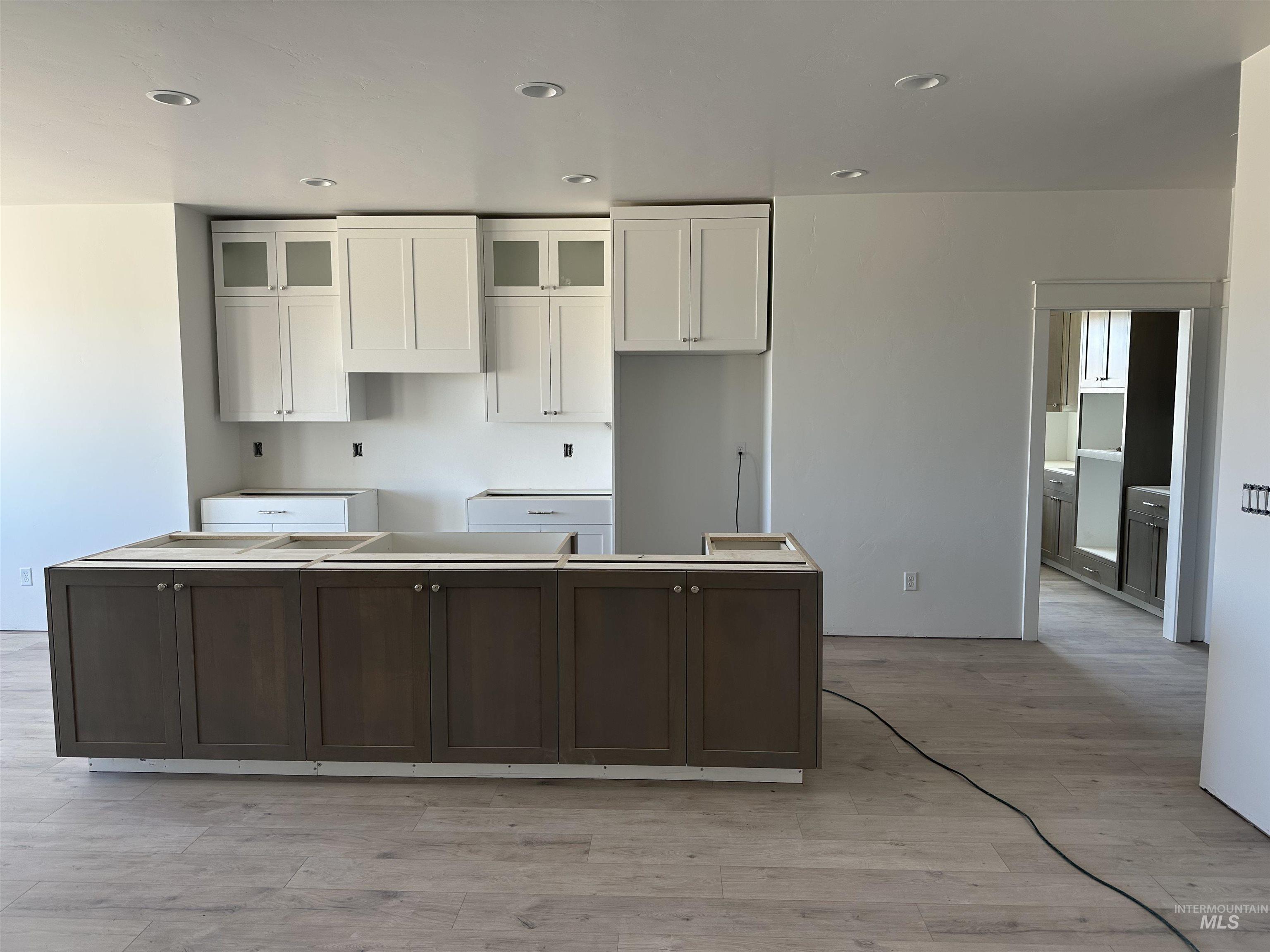 3035 Lake View Twin Falls, ID 83301 - Photo 4 of 18 Kitchen featuring a central island with wood-finish cabinetry, perimeter white upper and lower cabinetry, recessed lighting, and wood-finish flooring