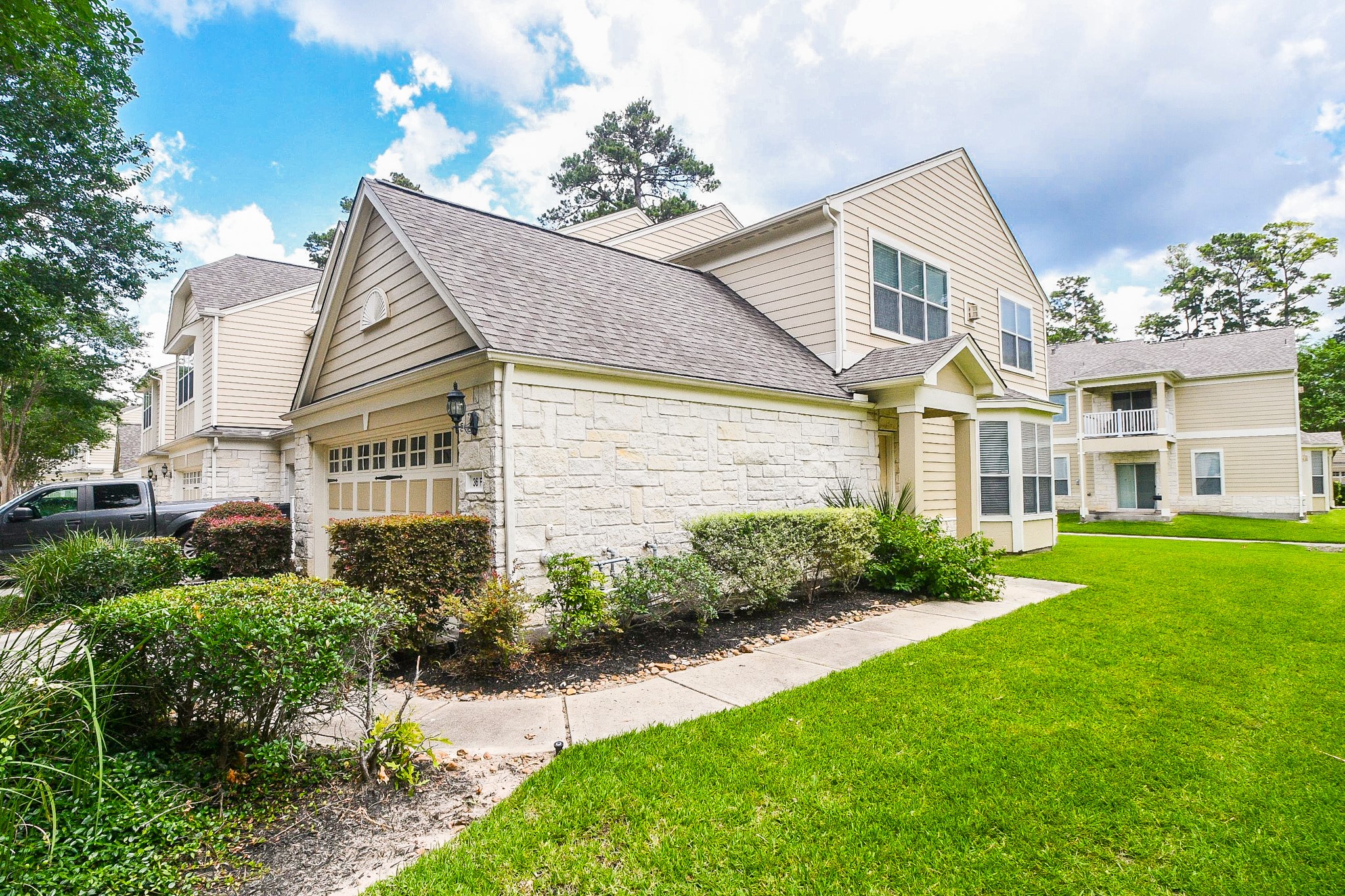 13600 Breton Ridge Street, Unit 36F Houston, TX 77070 - Photo 7 of 38 Charming side angle showcasing green space and a welcoming setting.