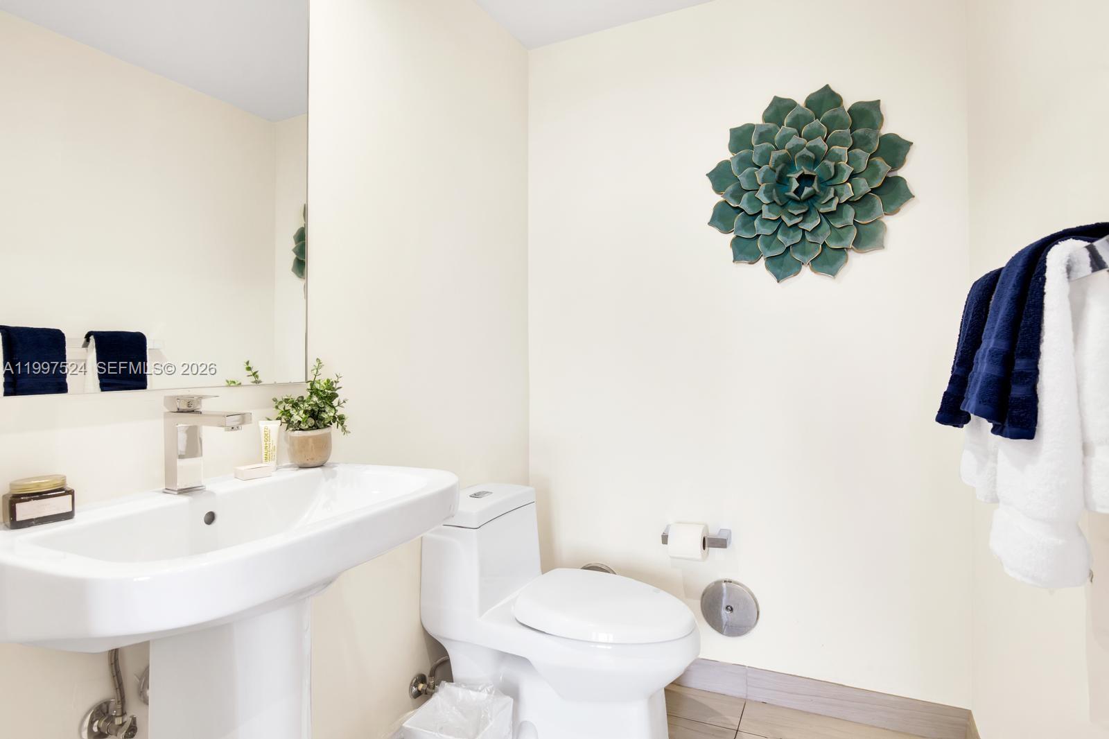 4010 South Ocean Drive, Unit R708 Hollywood, FL 33019 - Photo 19 of 35 a bathroom with a sink a toilet and mirror