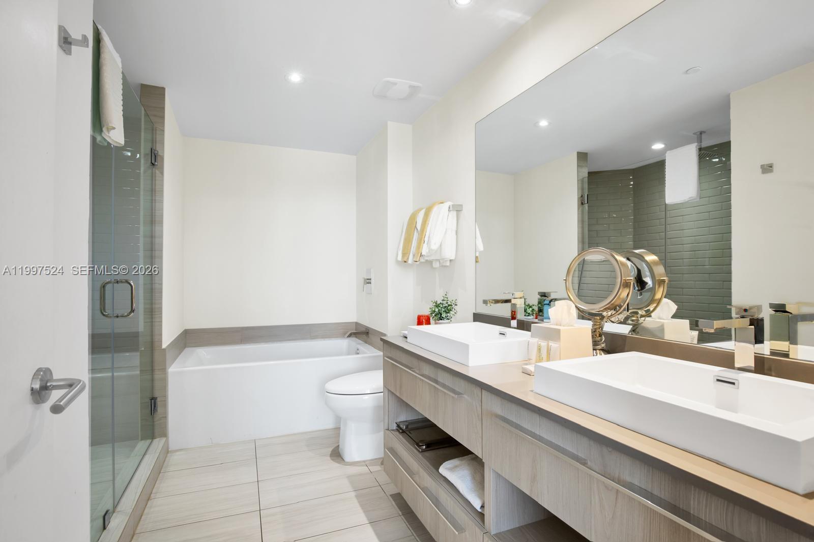 4010 South Ocean Drive, Unit R708 Hollywood, FL 33019 - Photo 32 of 35 a bathroom with a double vanity sink toilet mirror and bathtub