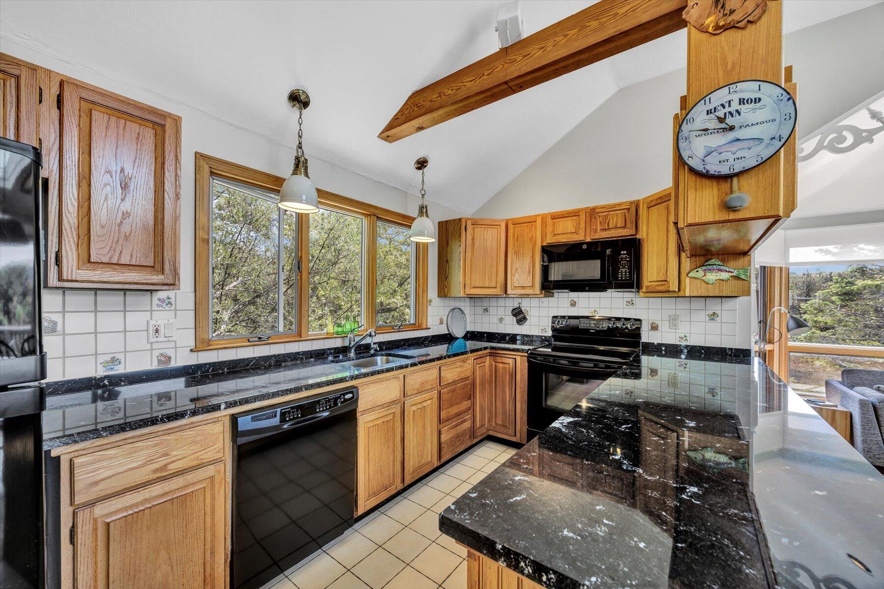 3 Amber Way Truro, MA 02666 - Photo 23 of 43 a kitchen with stainless steel appliances granite countertop a stove top oven a sink a dining table and chairs with the large window