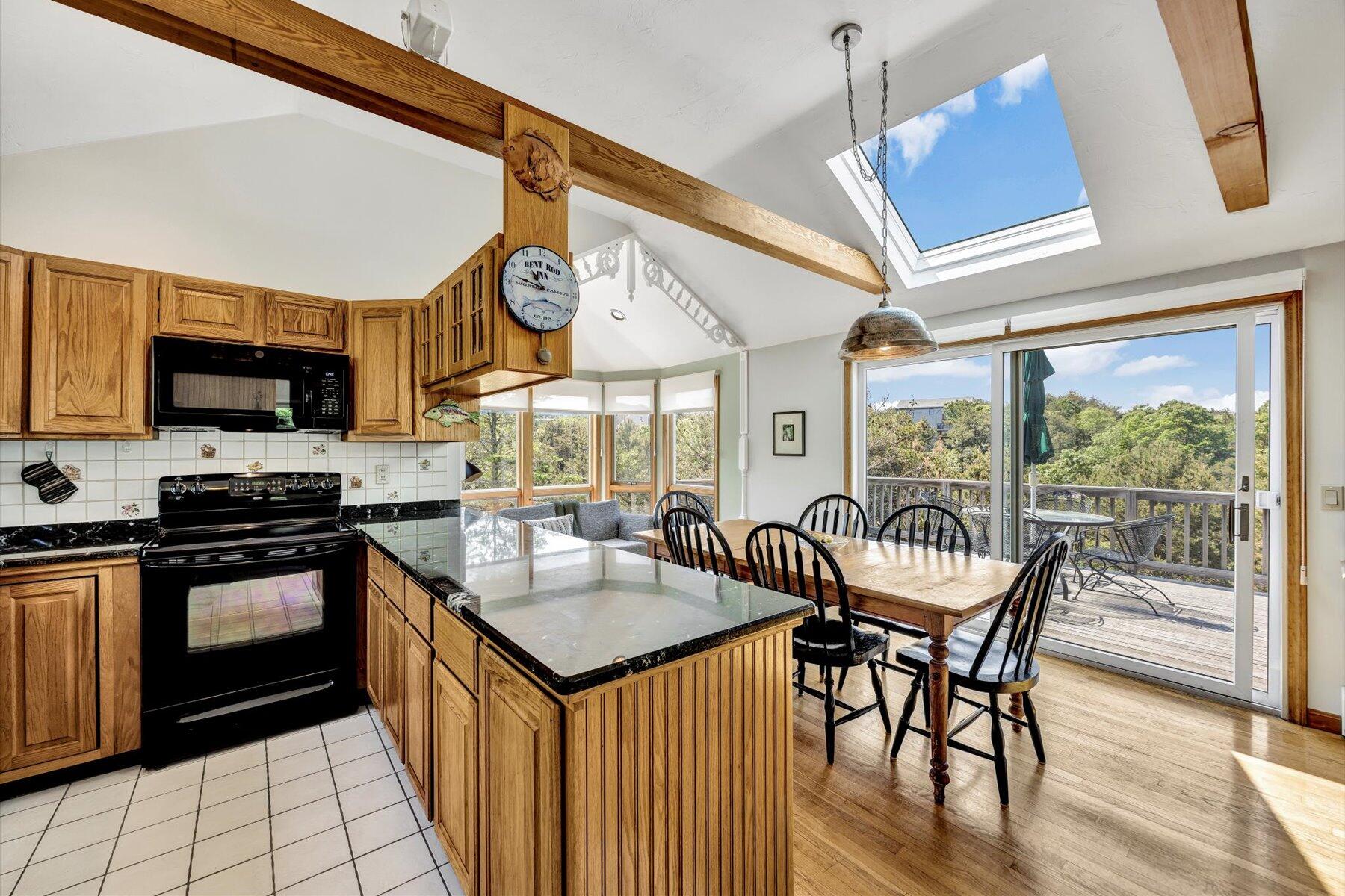 3 Amber Way Truro, MA 02666 - Photo 24 of 43 a kitchen with stainless steel appliances granite countertop a stove a sink dishwasher a dining table and chairs with wooden floor