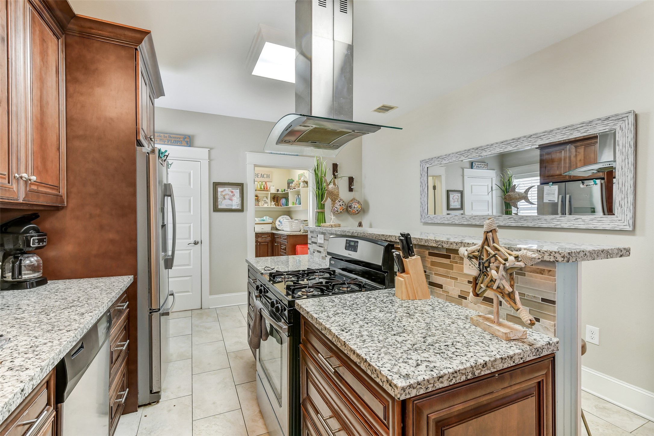 3807 Avenue R Galveston, TX 77550 - Photo 11 of 46 Equipped with a gas stove and sleek stainless steel appliances throughout. The open doorway in the back takes you into the huge laundry room.