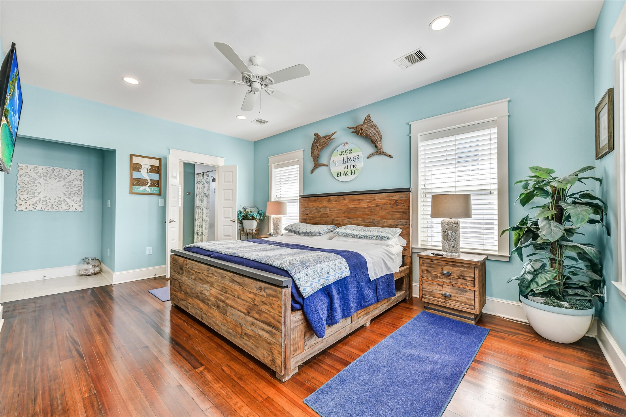 3807 Avenue R Galveston, TX 77550 - Photo 25 of 46 The gorgeous primary suite is the perfect place to unwind after a long day, featuring large windows, wood floors, and ample space for a king-size bed and seating area.