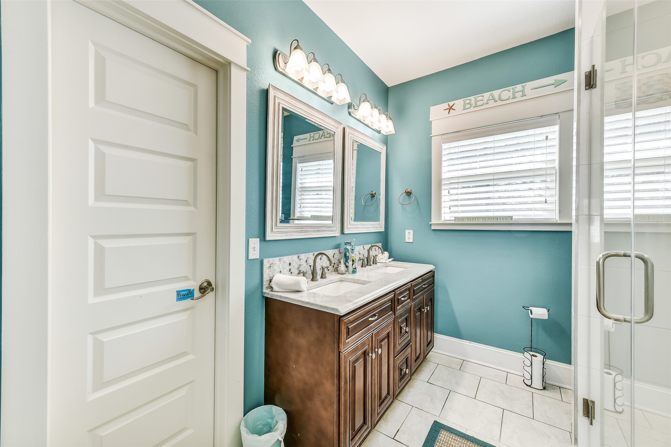 3807 Avenue R Galveston, TX 77550 - Photo 28 of 46 The spacious en-suite primary bath showcases tile floors, double vanities, granite countertops, a separate shower, a soaking tub with shower combo, and a walk-in closet accessed through the door to the left.
