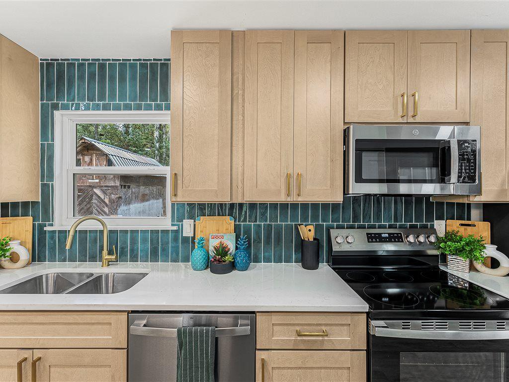 531 Carlton Road Palmetto, GA 30268 - Photo 15 of 38 a kitchen with kitchen island granite countertop a stove a sink and a microwave