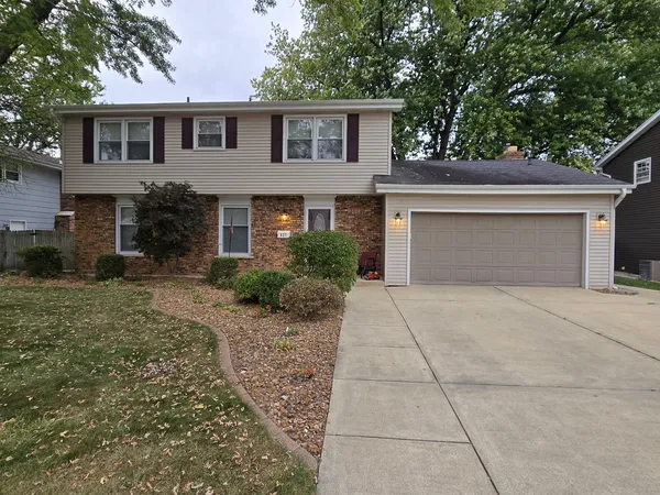 a front view of a house with a yard and trees