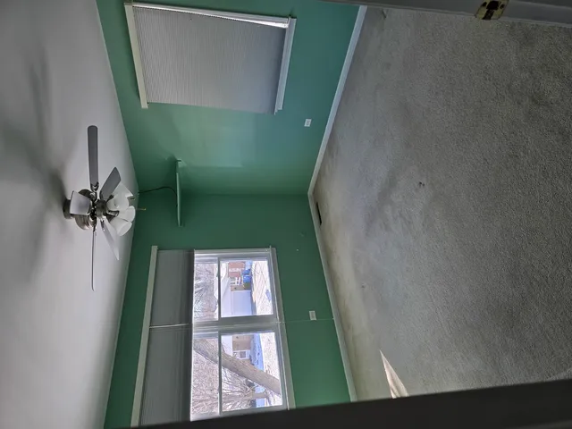 an empty room with a chandelier fan