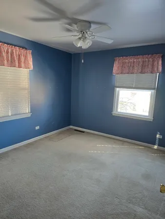 an empty room with a chandelier fan