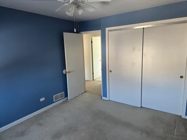 an empty room with a ceiling fan and a window