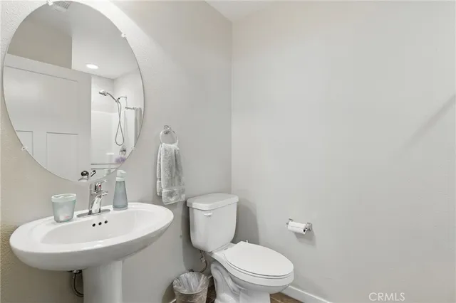 a bathroom with a sink a toilet and mirror