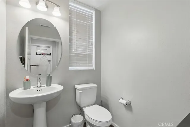a bathroom with a toilet a sink and mirror