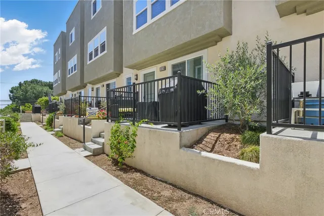 a view of a house with a small yard and potted plants