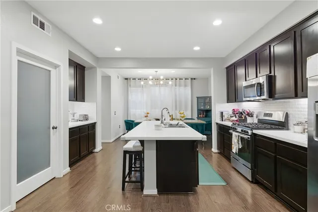 a kitchen with kitchen island granite countertop a sink stainless steel appliances and cabinets