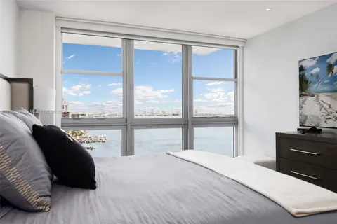 a bedroom with a bed and a large window