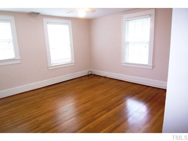 1807 Sunset Drive Raleigh, NC 27608 - Photo 6 of 10 an empty room with wooden floor and windows