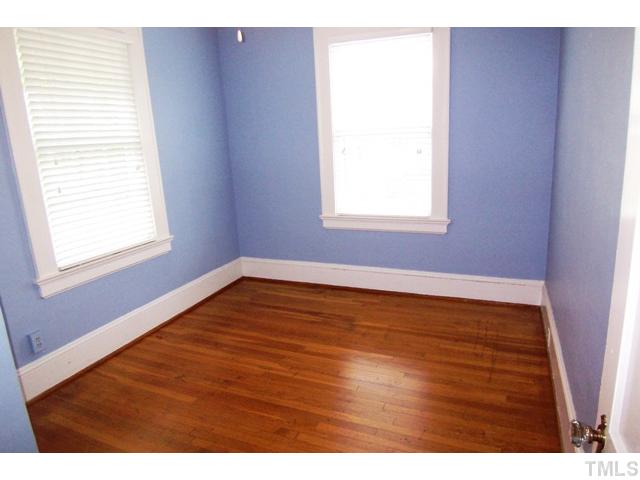 1807 Sunset Drive Raleigh, NC 27608 - Photo 8 of 10 a view of an empty room with wooden floor and a window