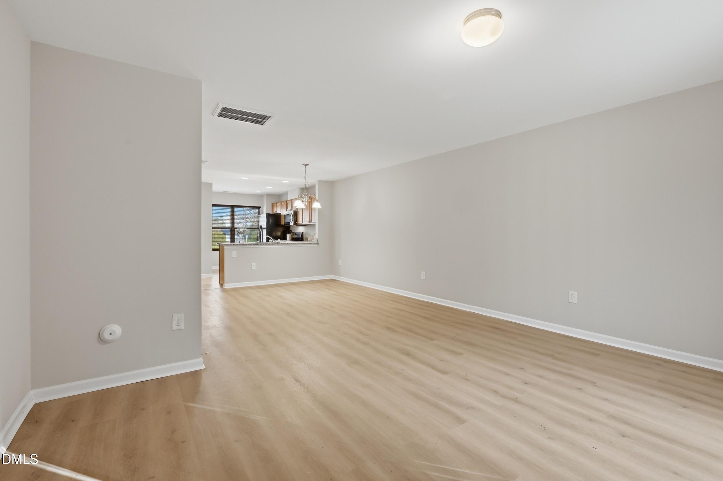 2907 Berkeley Springs Place Raleigh, NC 27616 - Photo 13 of 34 an empty room with wooden floor and windows