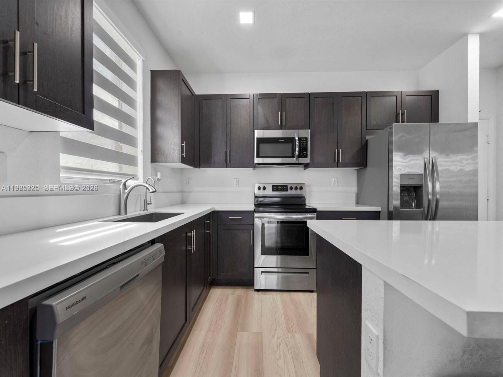 13391 Southwest 285th Street Homestead, FL 33033 - Photo 17 of 37 a kitchen with kitchen island a sink appliances and cabinets