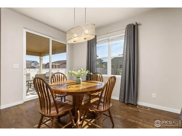a dining room with furniture a chandelier and wooden floor