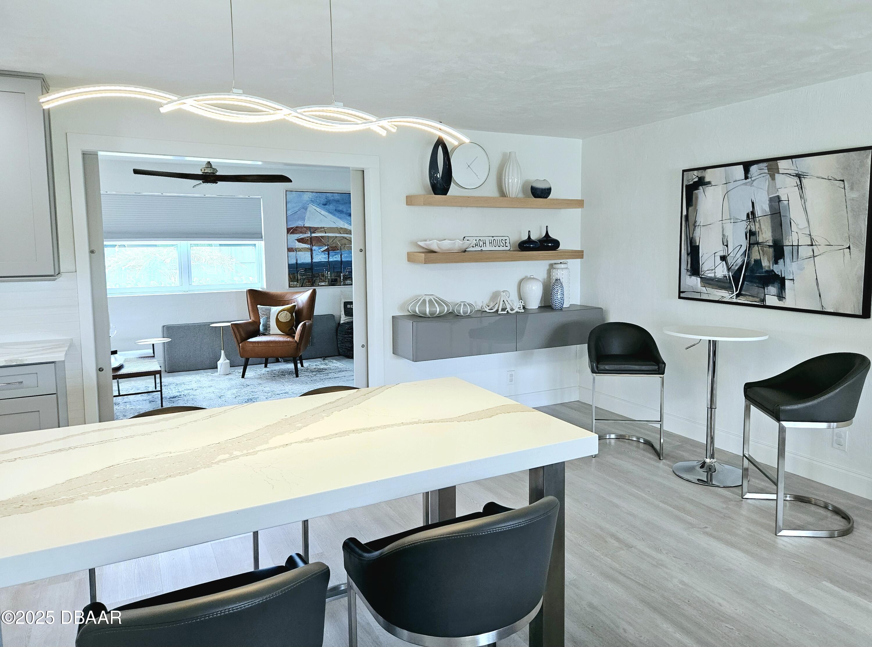 13 Sunrise Avenue Ormond Beach, FL 32176 - Photo 10 of 52 a room with stainless steel appliances kitchen island granite countertop a table chairs and a wooden floor