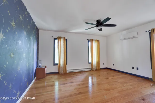 a view of empty room with wooden floor and window
