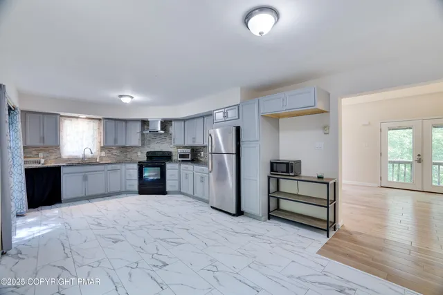 a large kitchen with a large counter top stainless steel appliances and cabinets