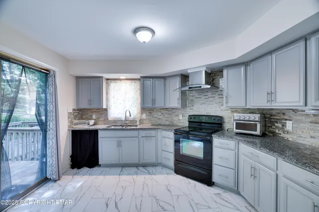 a kitchen with stainless steel appliances granite countertop a stove top oven sink and cabinets
