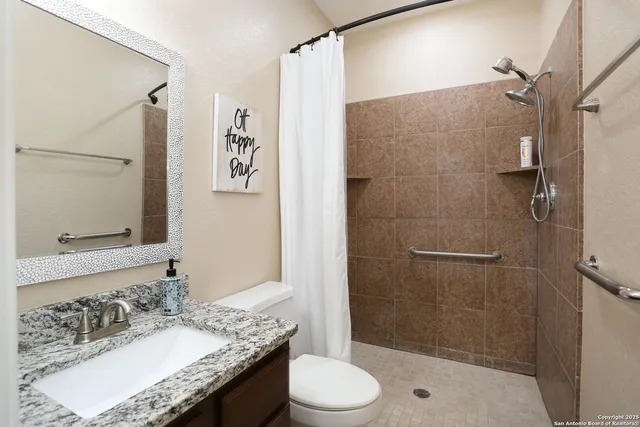 a view of a small house with a yard and a large tree