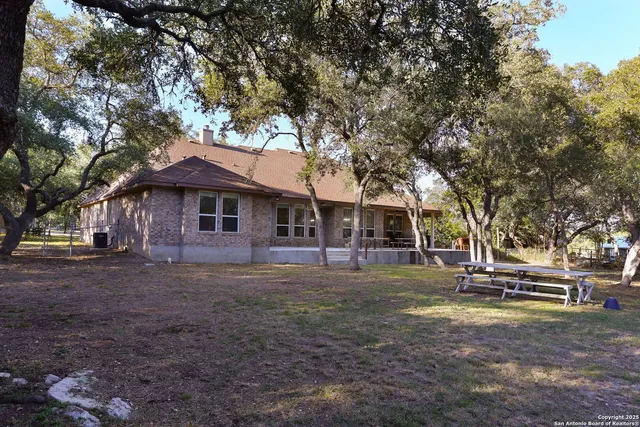 an aerial view of residential houses with outdoor space and trees