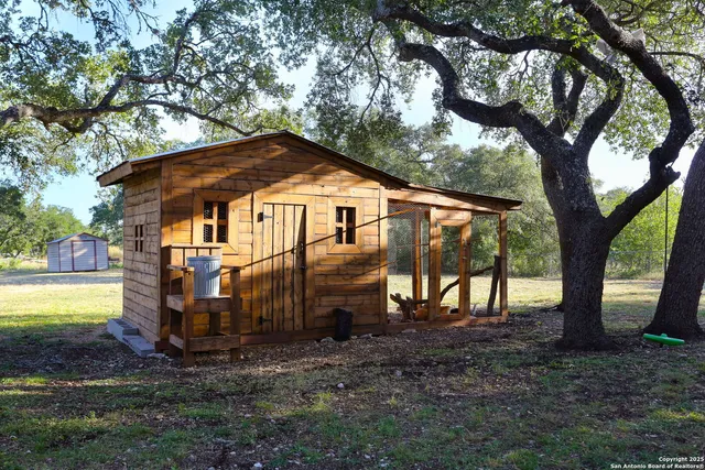 an aerial view of residential houses with outdoor space and trees