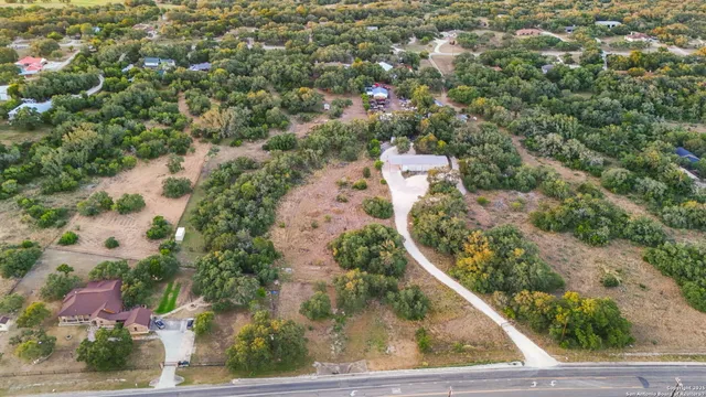 an aerial view of residential house with outdoor space and trees all around