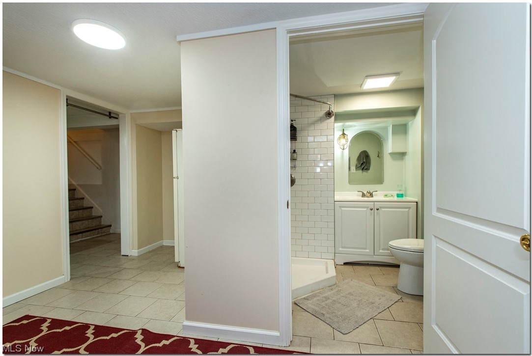 1430 West Miner Road Cleveland, OH 44124 - Photo 27 of 32 Full basement Bathroom featuring tile floors, toilet, oversized vanity, and tiled shower