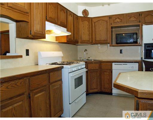 28 Stiles Road Edison, NJ 08817 - Photo 17 of 25 a kitchen with stainless steel appliances a stove a microwave a sink and cabinets
