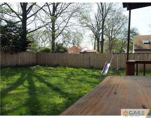 28 Stiles Road Edison, NJ 08817 - Photo 24 of 25 a view of a backyard with large trees and wooden fence