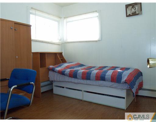 28 Stiles Road Edison, NJ 08817 - Photo 6 of 25 a bedroom with a bed and a chair