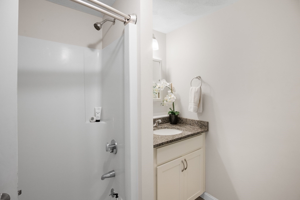 730 Wellman Avenue, Unit 730 Chelmsford, MA 01863 - Photo 21 of 31 a bathroom with a granite countertop shower and a sink