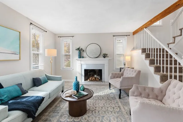 a living room with furniture a fireplace and a large window