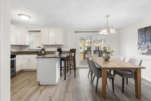 a kitchen with stainless steel appliances granite countertop a kitchen island a stove a table and a sink