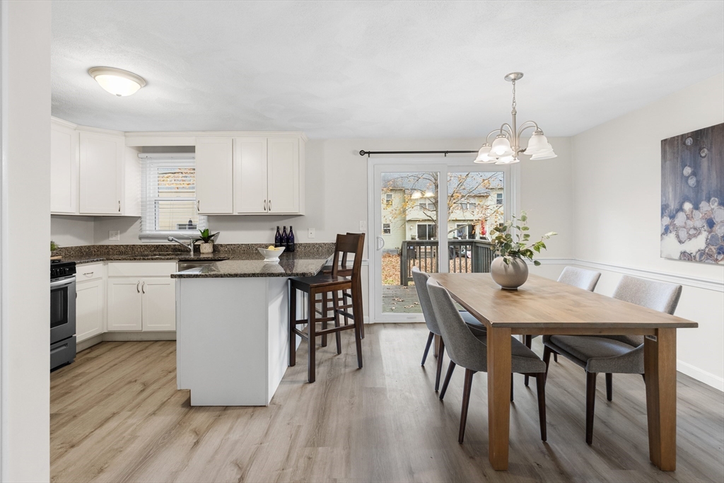 730 Wellman Avenue, Unit 730 Chelmsford, MA 01863 - Photo 6 of 31 a kitchen with stainless steel appliances granite countertop a kitchen island a stove a table and a sink