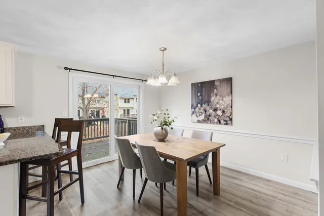 a dining room with furniture a chandelier and wooden floor