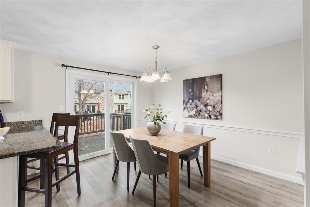 730 Wellman Avenue, Unit 730 Chelmsford, MA 01863 - Photo 7 of 31 a dining room with furniture a chandelier and wooden floor