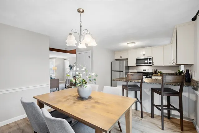 a view of a dining room and a kitchen with a table chairs