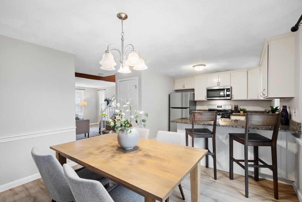 730 Wellman Avenue, Unit 730 Chelmsford, MA 01863 - Photo 10 of 31 a view of a dining room and a kitchen with a table chairs