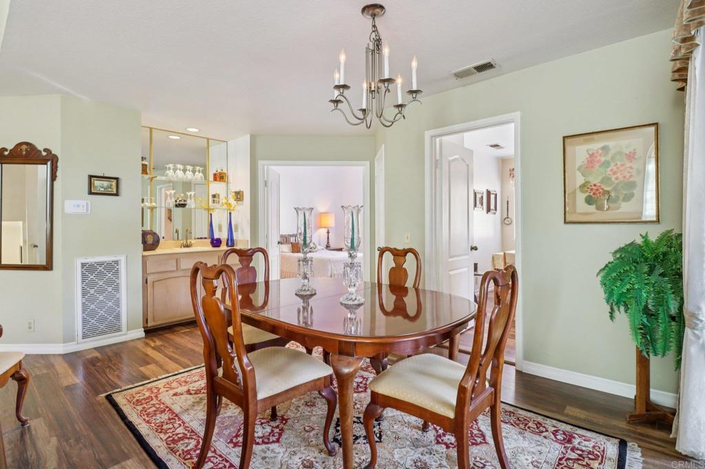 7747 Caminito Monarca, Unit 100 Carlsbad, CA 92009 - Photo 13 of 67 a view of a dining room with furniture and chandelier